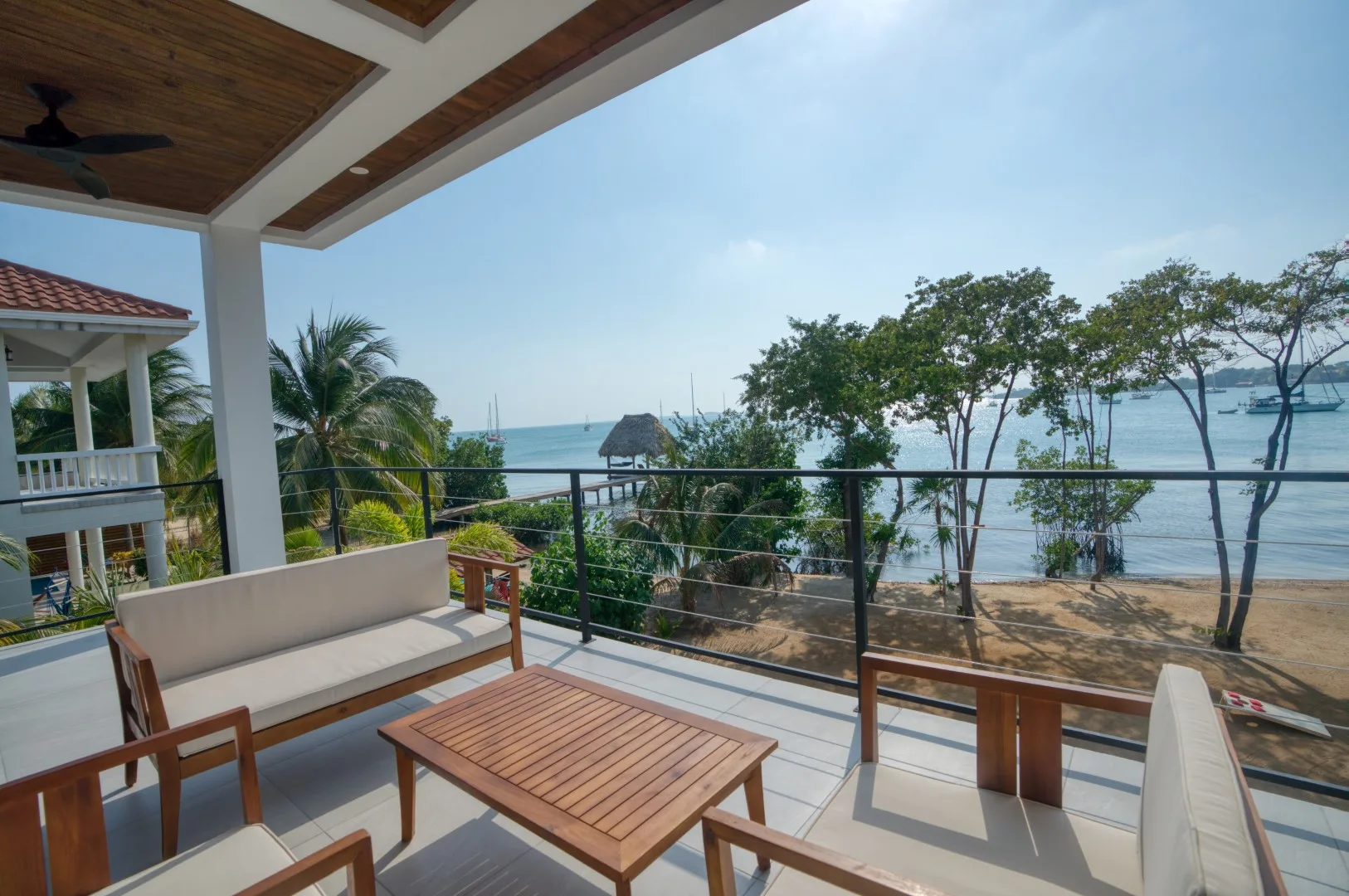 A covered outdoor seating area overlooks trees and the water.