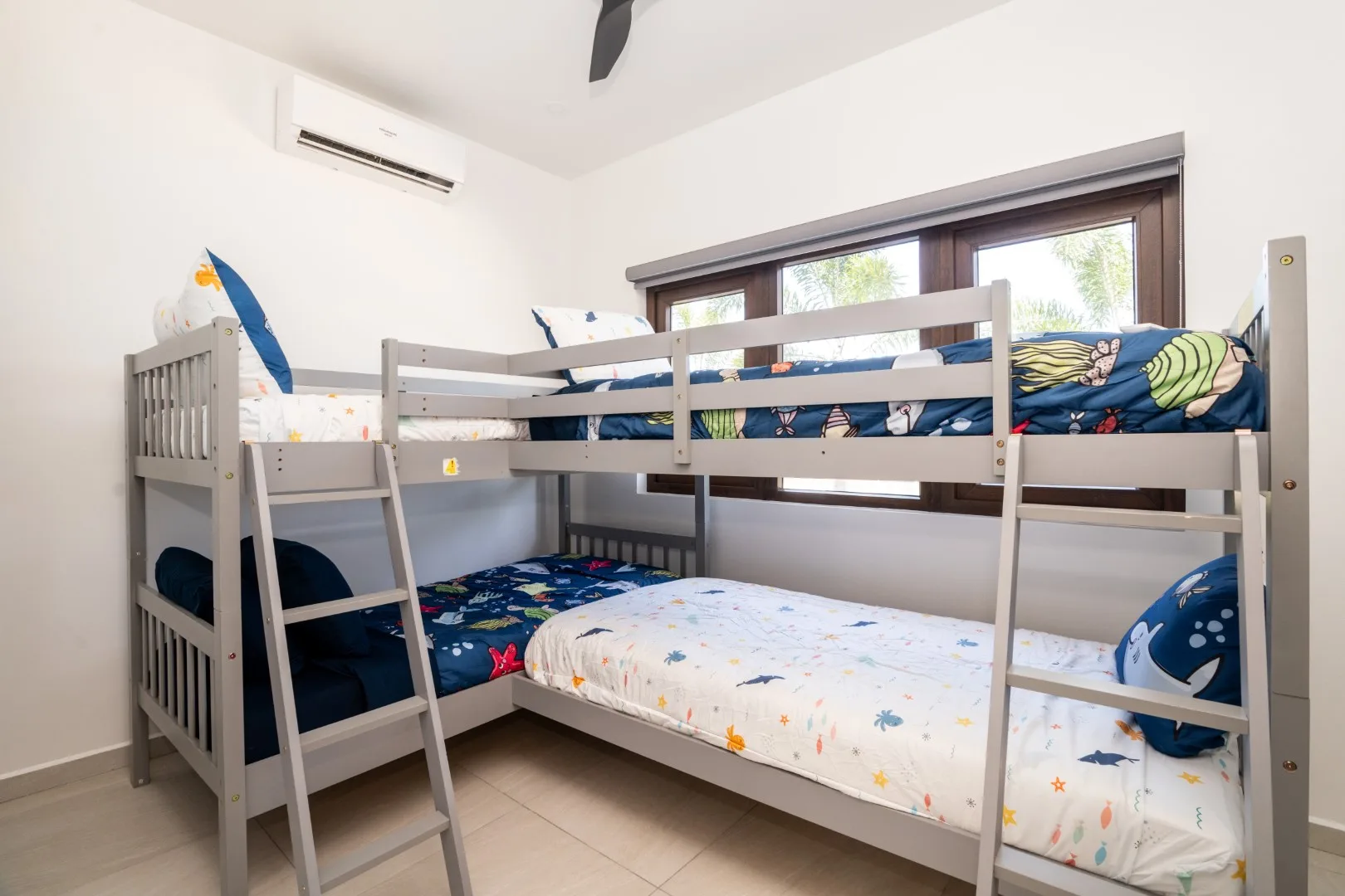 A bunk bedroom with two sleeping levels and colorful patterned bedding.