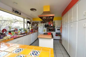 Representative hotel space: A kitchen with white cabinets, appliances, and a central island.