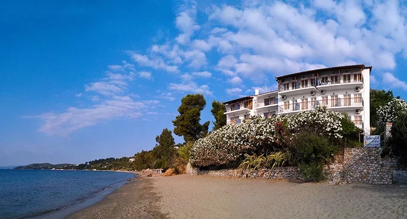 Espacio representativo del hotel: Un hotel frente a la playa da al agua azul y una orilla arenosa.