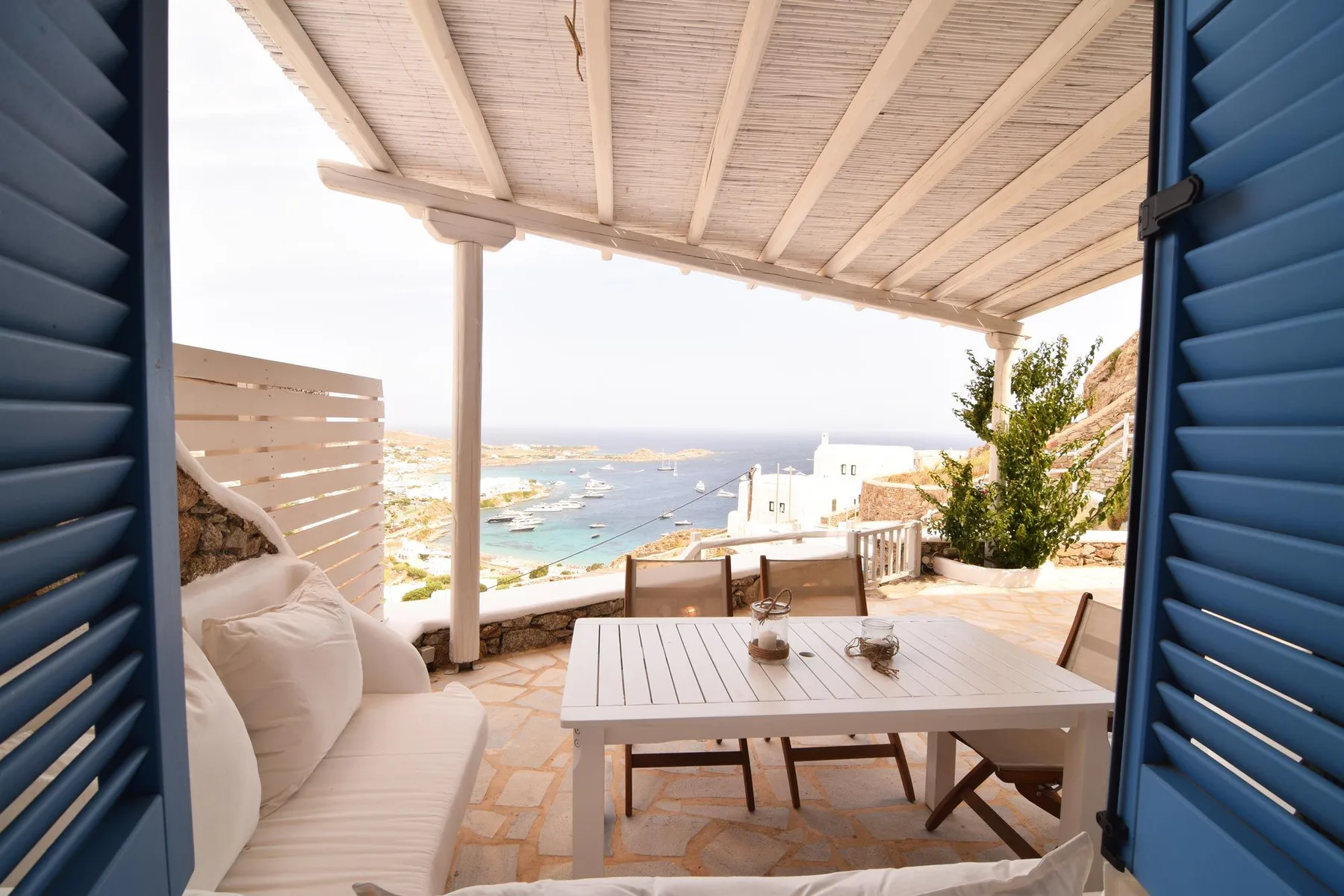 A seaside terrace with outdoor seating overlooks the water.