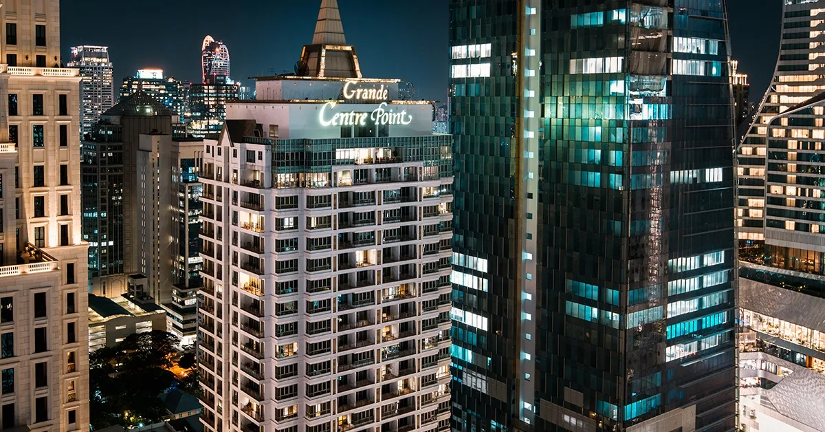 Espacio representativo del hotel: El horizonte nocturno de la ciudad muestra un edificio destacado con letrero iluminado.
