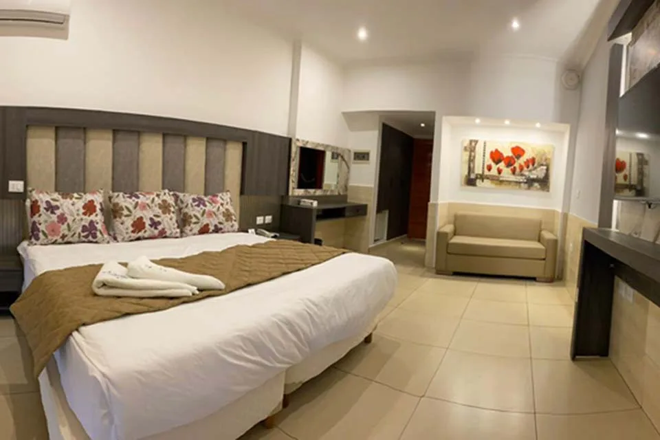 Espacio representativo del hotel: Dormitorio con una cama grande y una pequeña zona de estar.