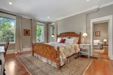 Representative hotel space: A bedroom with a bed, bedside tables, and a patterned rug.
