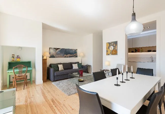 A bright living and dining area with a table, seating, and a sofa.