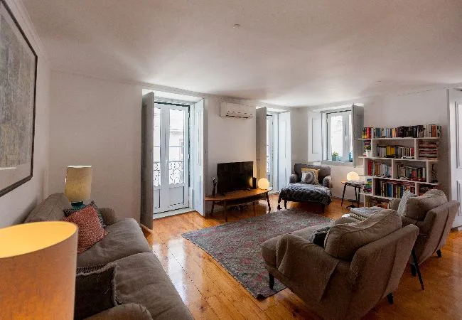 Sala de estar con asientos, un televisor y estanterías.