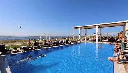 Espacio representativo del hotel: Una piscina al aire libre da a la costa, con tumbonas junto al agua.