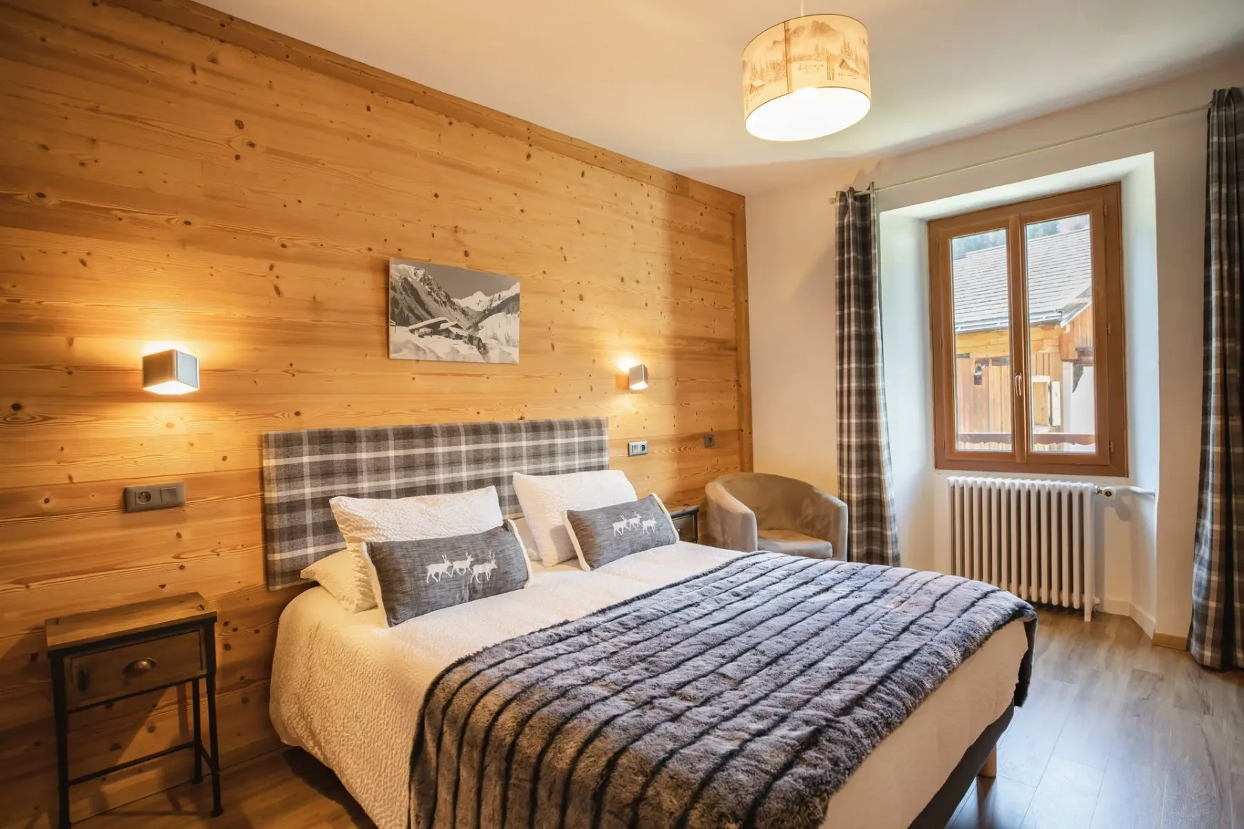 Espacio representativo del hotel: Un dormitorio con una cama, una pared de madera y una ventana.