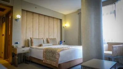 Espacio representativo del hotel: Un dormitorio con una cama y asientos junto a una ventana luminosa.