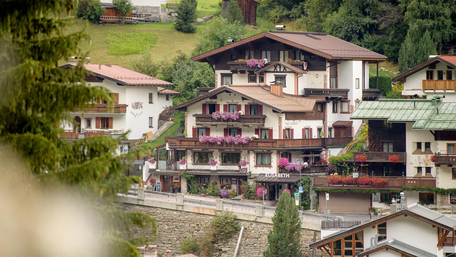Representative hotel space: A cluster of chalet-style buildings sits on a green hillside.