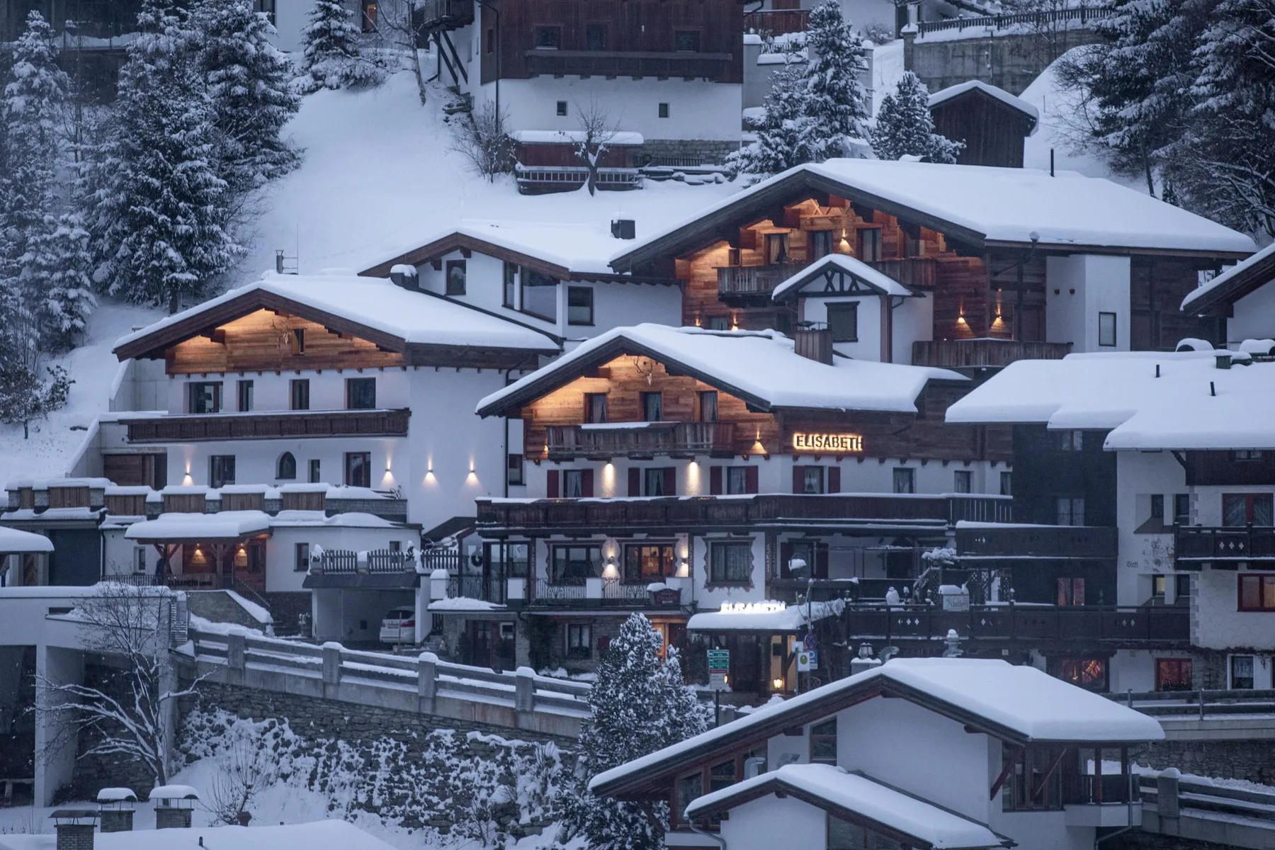 Representative hotel space: Snow-covered mountain buildings with warmly lit windows.