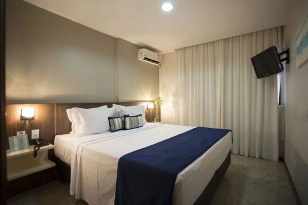 Espacio representativo del hotel: Un dormitorio con una cama, mesas de noche y cortinas.