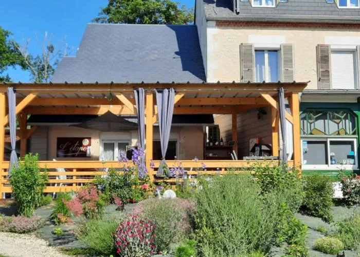 Representative hotel space: A restaurant patio with a wooden pergola and garden planting.