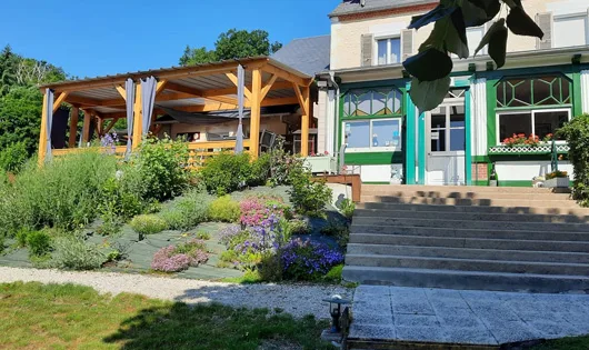 Representative hotel space: A landscaped garden and stone steps lead to a green-trimmed building.