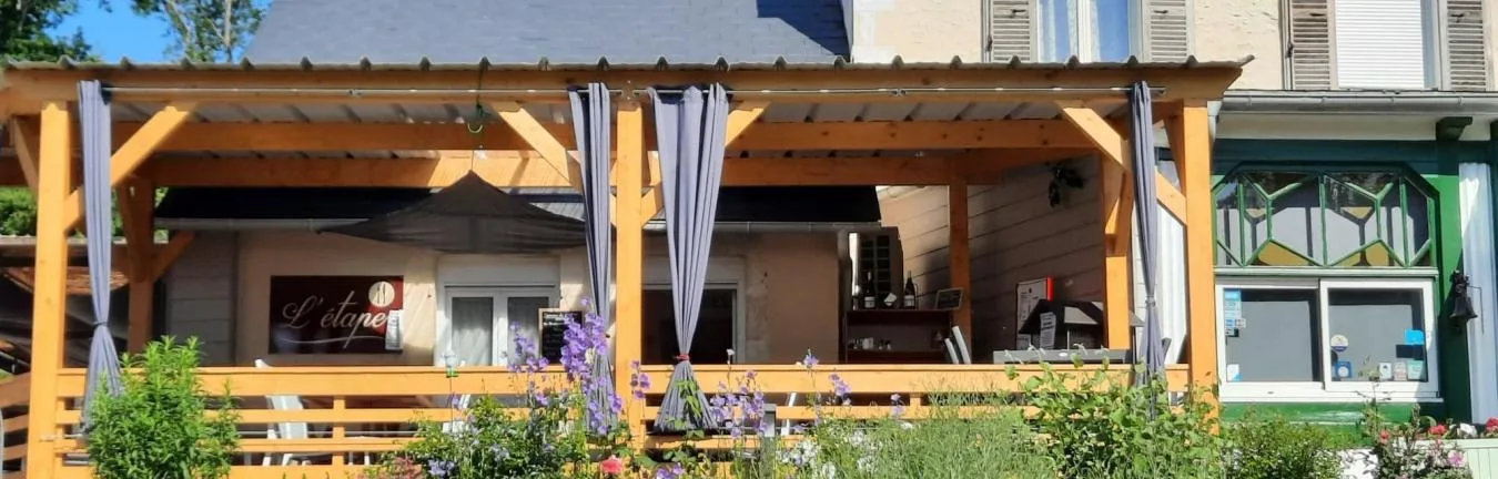 Representative hotel space: An outdoor patio with wooden seating, overhead shade, and flowering plants.