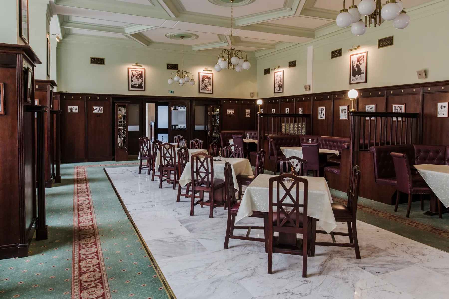 Espacio representativo del hotel: Un comedor con mesas y sillas dispuestas junto a un pasillo de mármol.