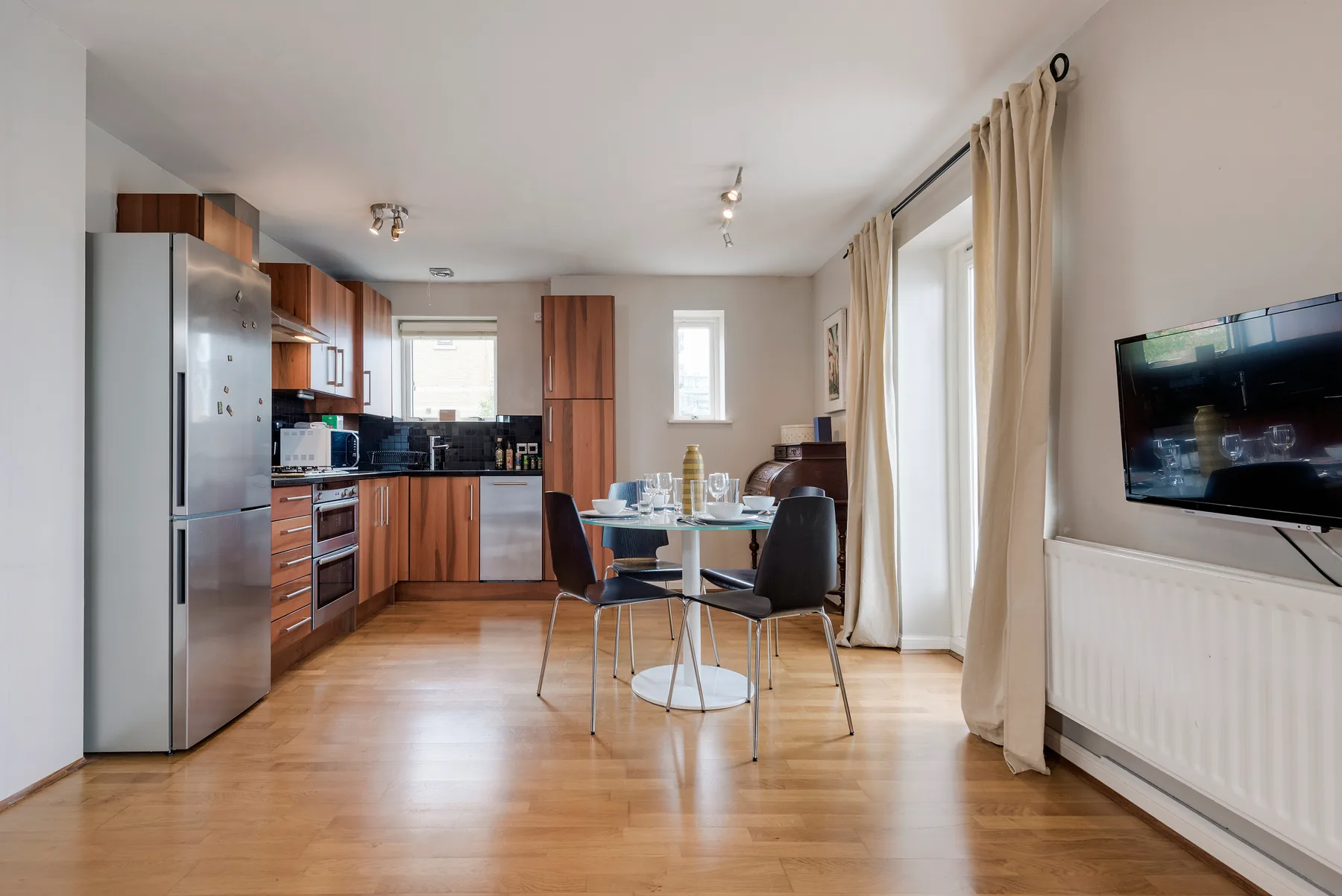 A kitchen and dining area with wooden cabinets, a table, and chairs.