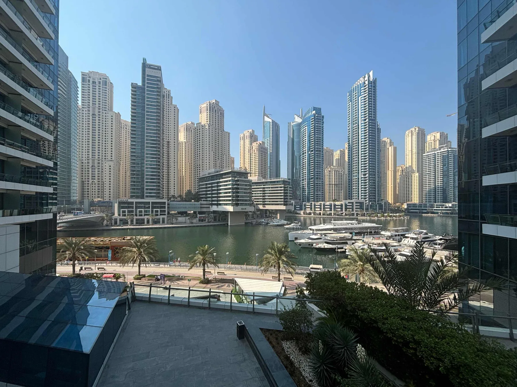 Shared amenity: A waterfront marina with boats sits below a skyline of tall buildings.