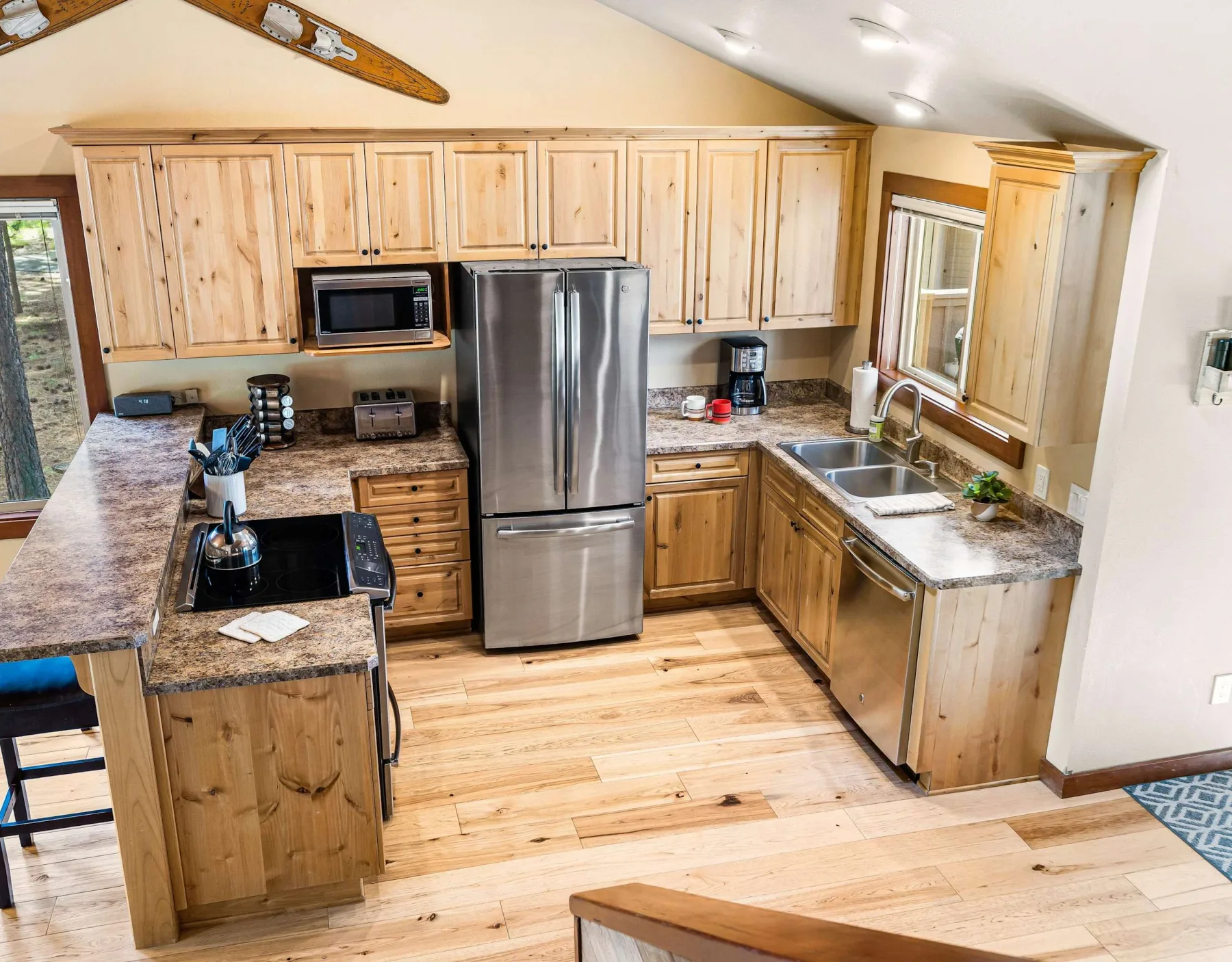 A kitchen with wooden cabinets, a refrigerator, and a sink.