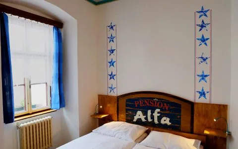 Representative hotel space: A bedroom with a wooden headboard and a window with blue curtains.