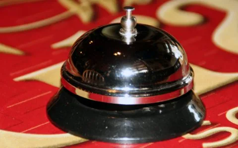 Representative hotel space: A service bell rests on a red patterned surface.