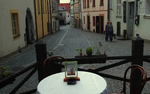 Representative hotel space: A cobblestone street is viewed from an outdoor café table with a menu display.