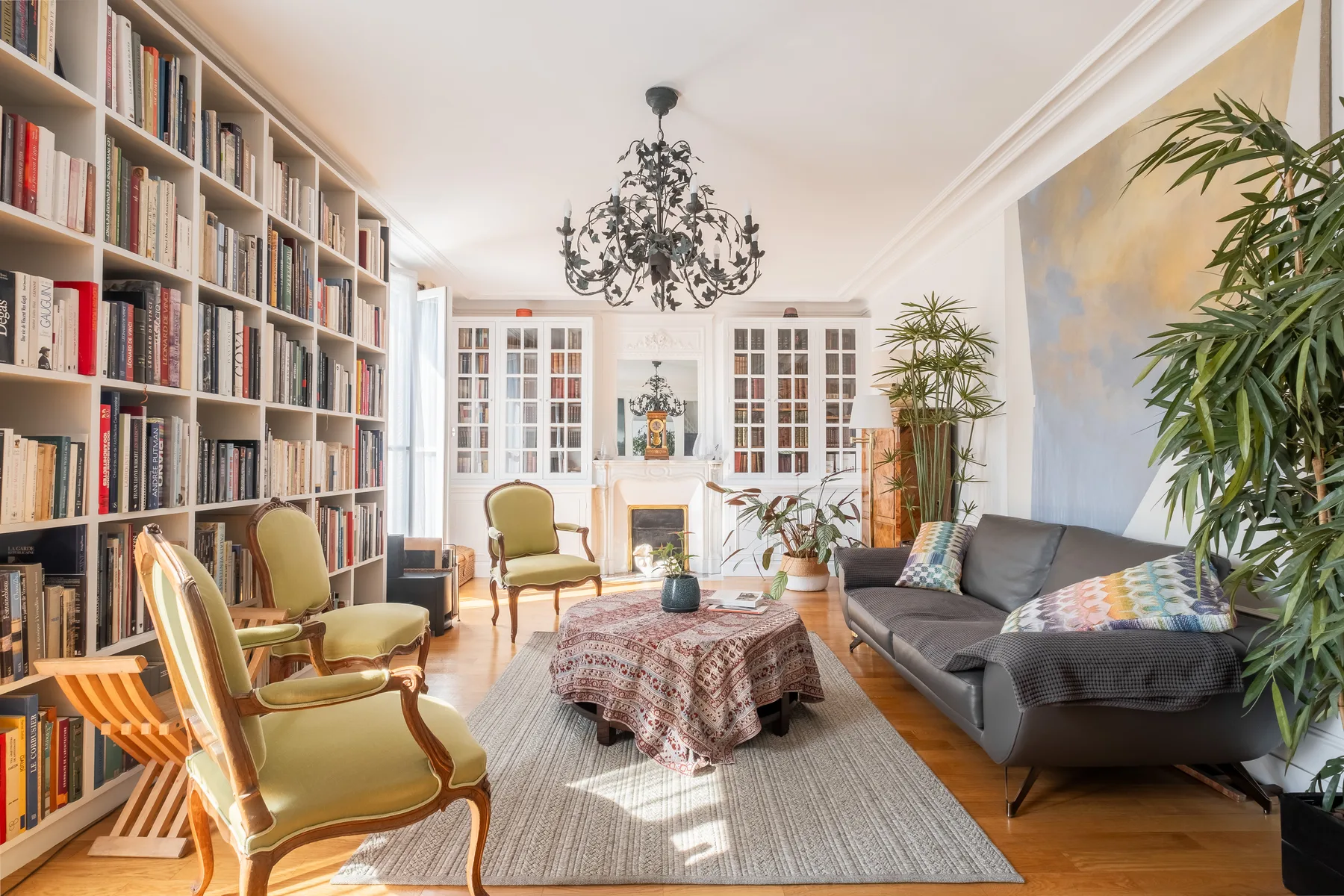 A bright living room with bookshelves, seating, and a central coffee table.