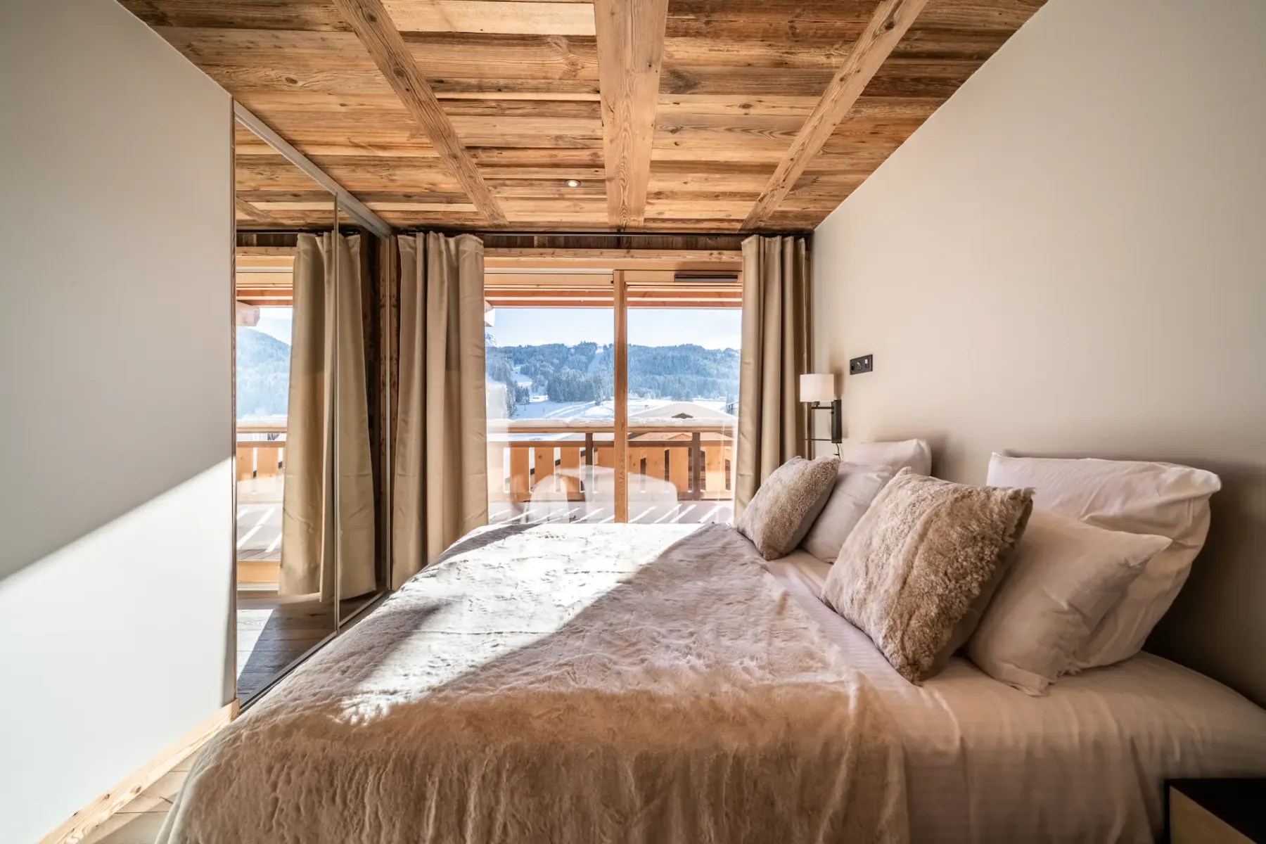 Un dormitorio con una cama junto a puertas de vidrio que dan a un balcón.