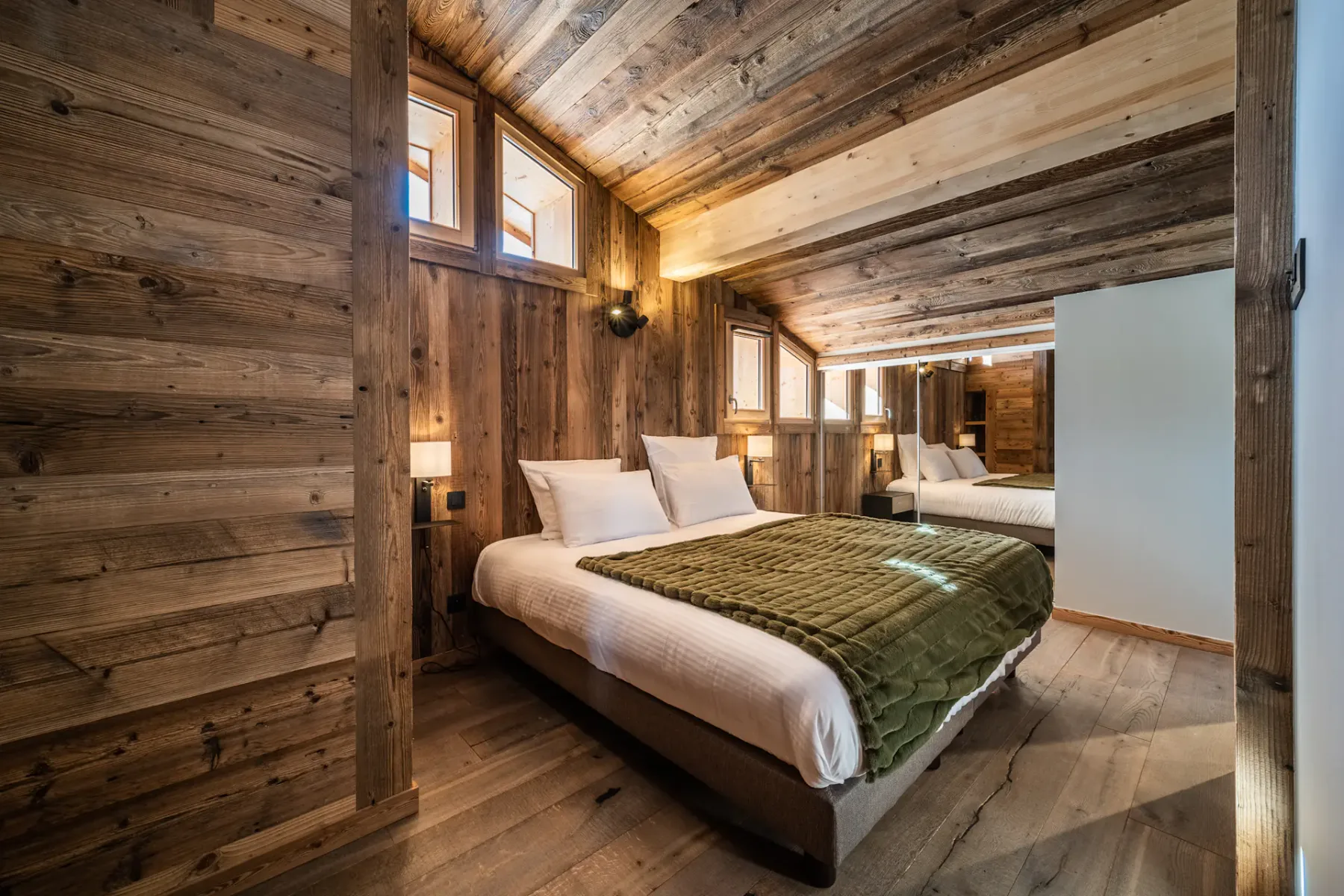 Un dormitorio con una cama bajo un techo de tablones de madera.