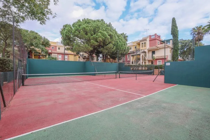 Shared amenity: An outdoor tennis court with a net and surrounding buildings.