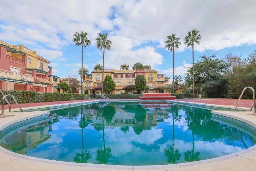 Shared amenity: A swimming pool sits among landscaped grounds and colorful buildings.