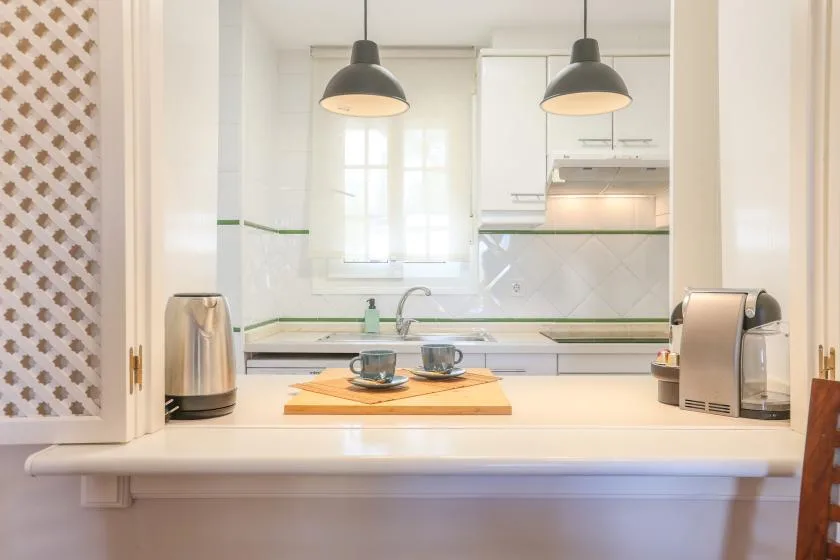 A bright kitchen with a countertop and two pendant lights.