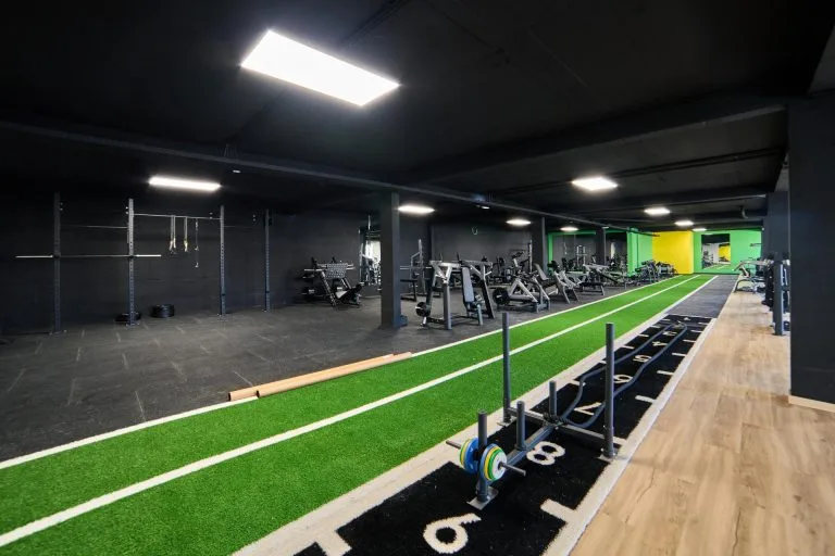 Representative hotel space: A gym with exercise machines beside a green indoor training track.