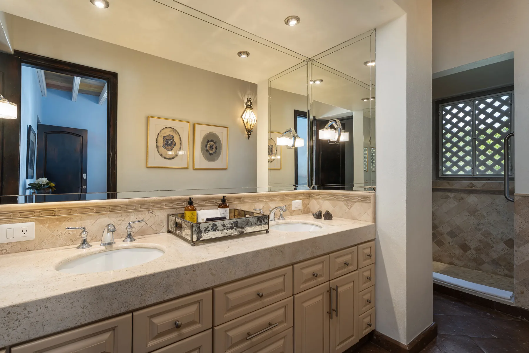 A bathroom vanity with two sinks and a large wall mirror.