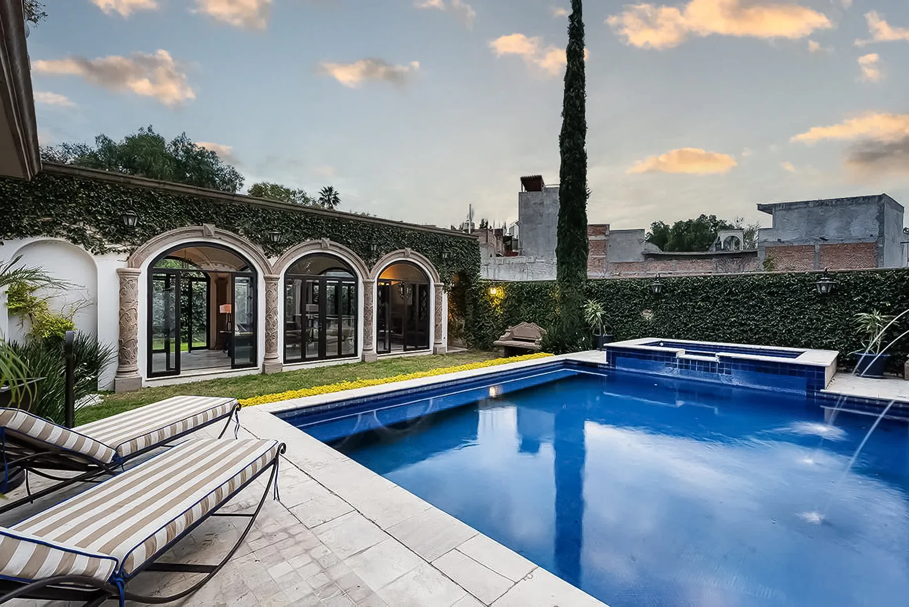 Shared amenity: A swimming pool beside an ivy-covered building with arched windows.