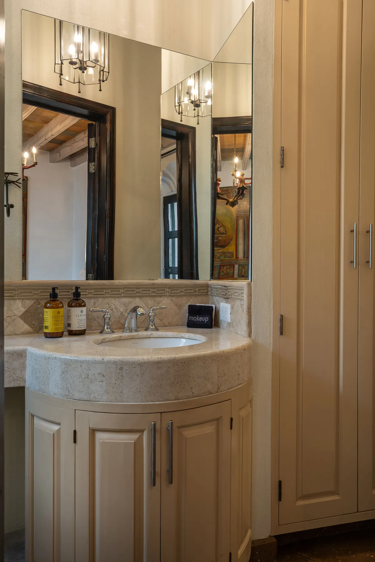 A bathroom vanity with a sink and a large wall mirror.