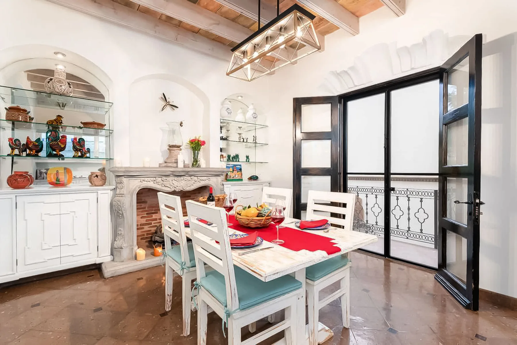 A dining area with a set table beside open glass doors.