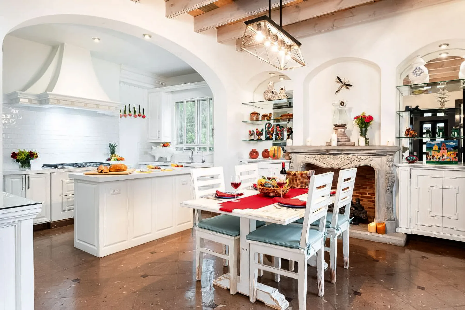 A bright kitchen and dining area with a white island and a long table.