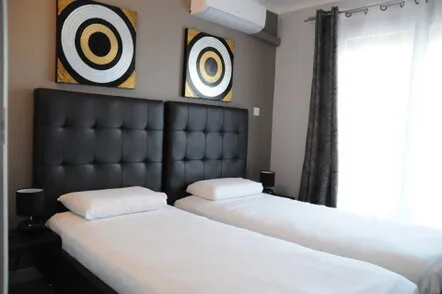 Espacio representativo del hotel: Un dormitorio con dos camas bajo cuadros circulares a juego.