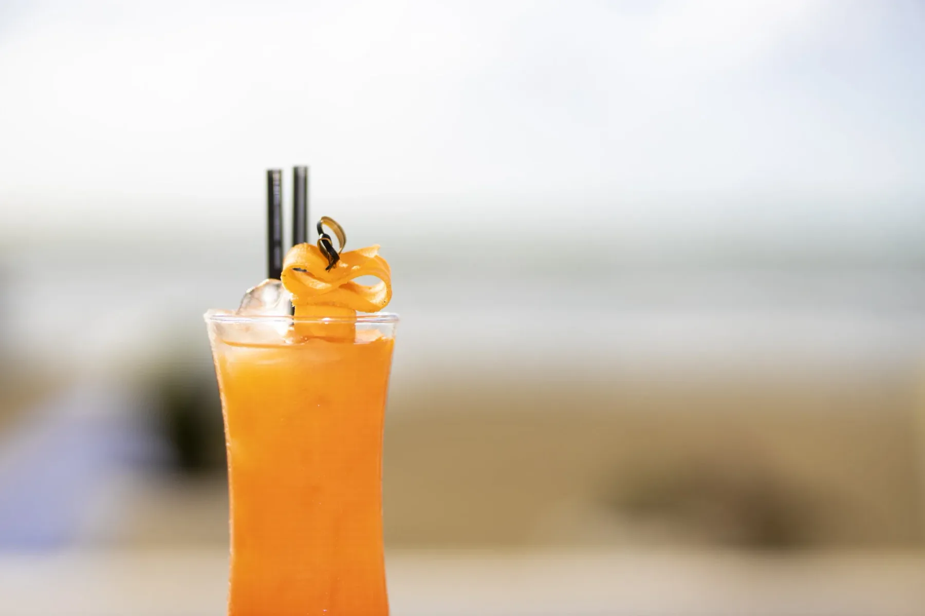 Representative hotel space: An orange drink is garnished with citrus and served with straws.