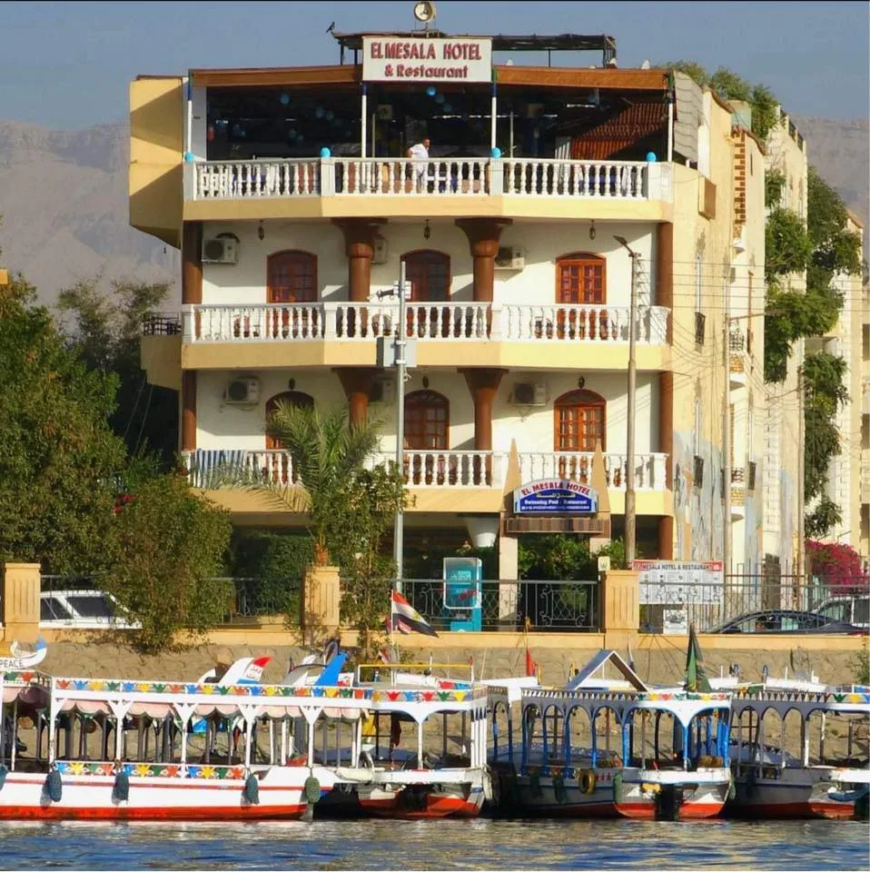 Espacio representativo del hotel: Un edificio hotelero de varios pisos está junto al agua, con barcos en primer plano.