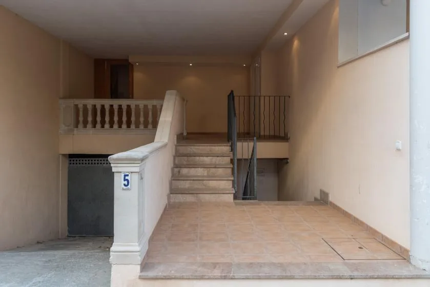 Shared amenity: An interior stairwell with tiled flooring and a railing.