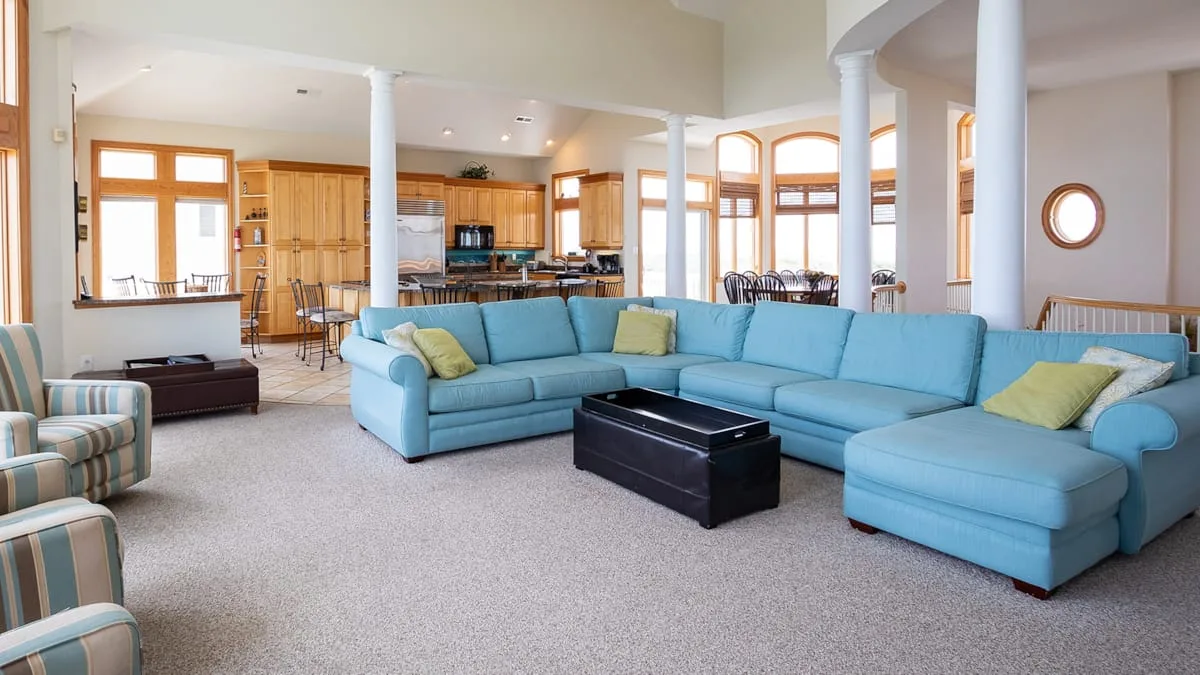 A spacious living room with a large blue sectional and a coffee table.