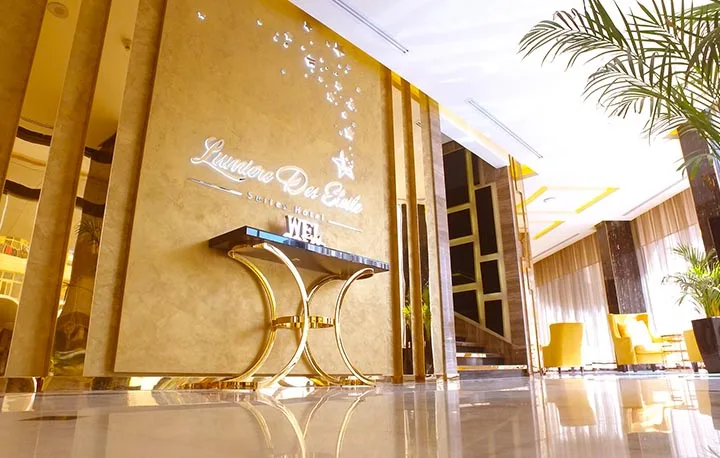 Espacio representativo del hotel: Vestíbulo de hotel con un letrero decorativo en la pared y una mesa pequeña.