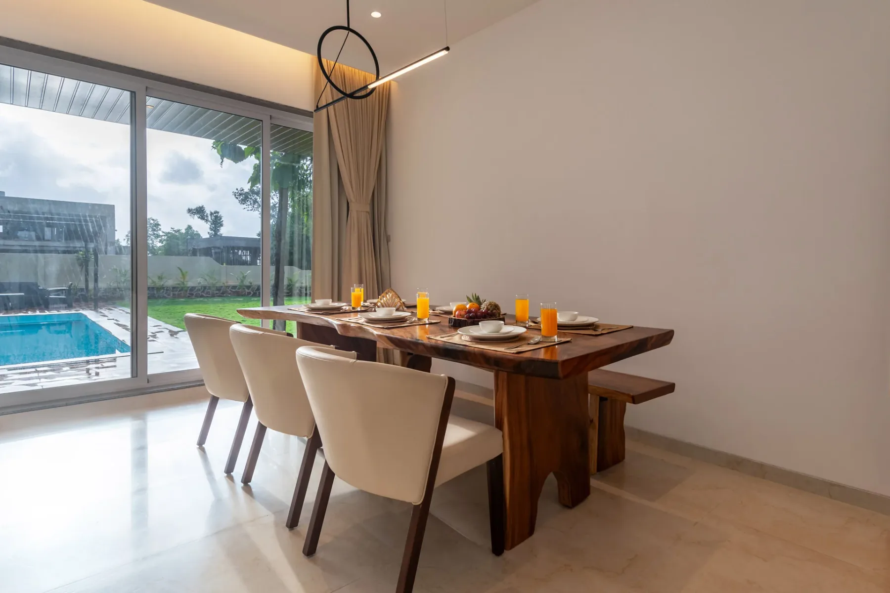 Comedor con una mesa larga puesta junto a grandes puertas de vidrio.