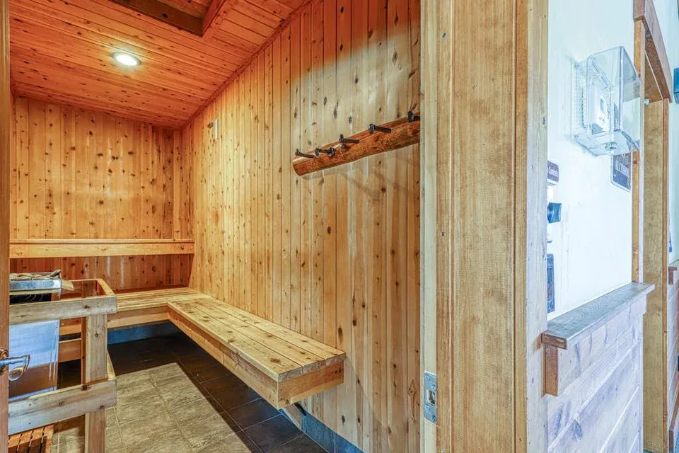 Shared amenity: A wood-paneled sauna room with built-in benches and a wall-mounted heater.