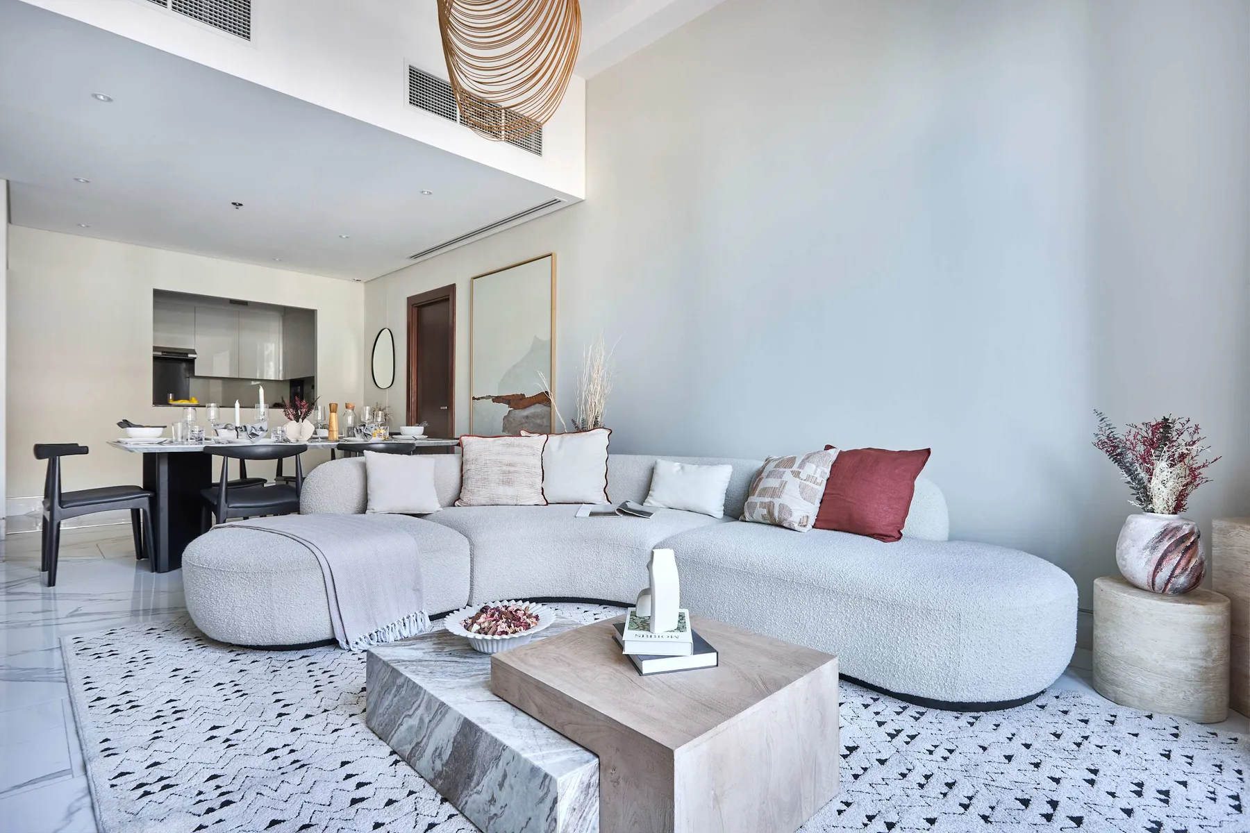 A bright living room with a curved sectional sofa and a low coffee table.