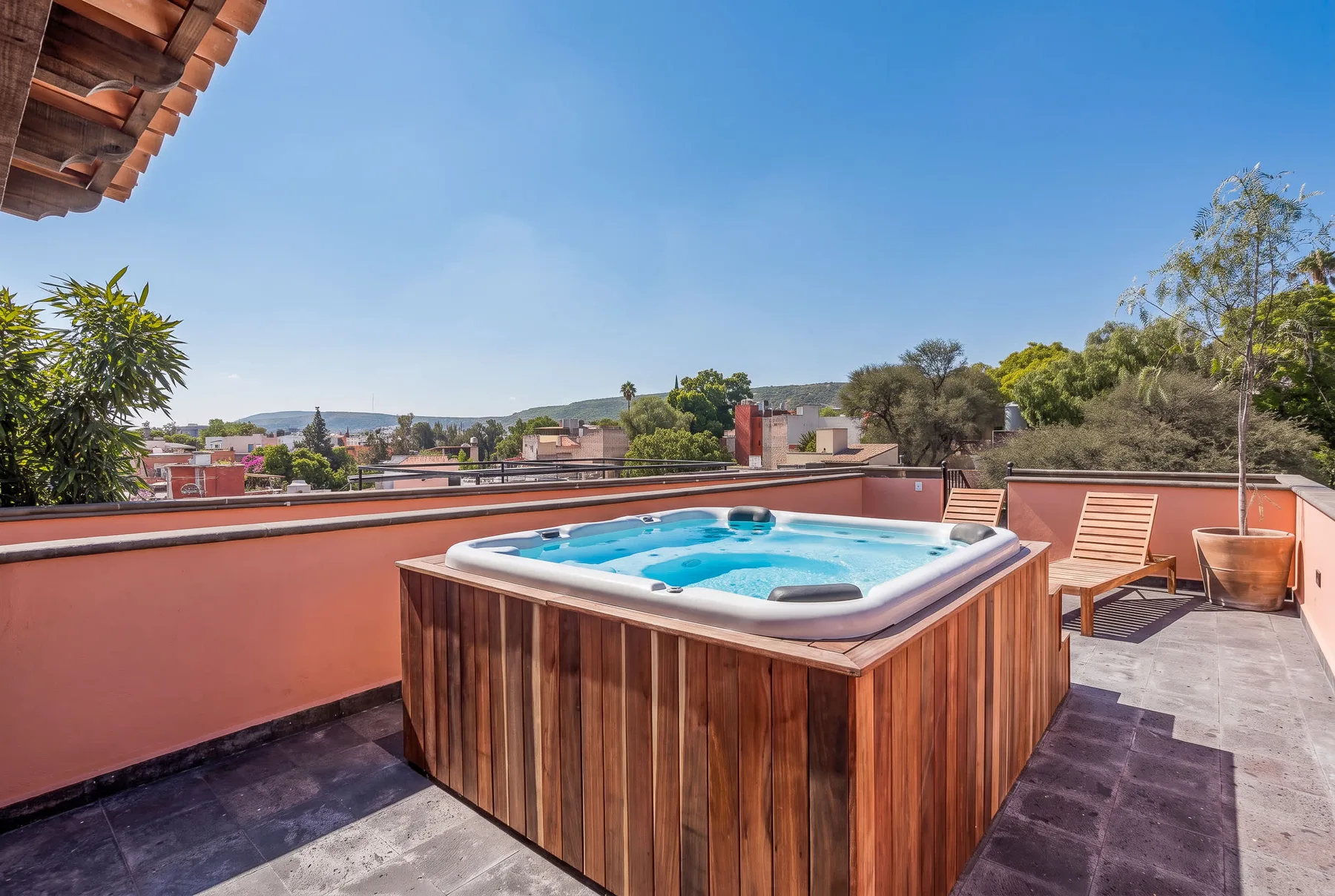 Una bañera de hidromasaje está en una terraza bajo un cielo despejado.