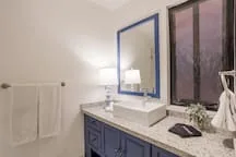 Un lavabo de baño con espejo está junto a una ducha.