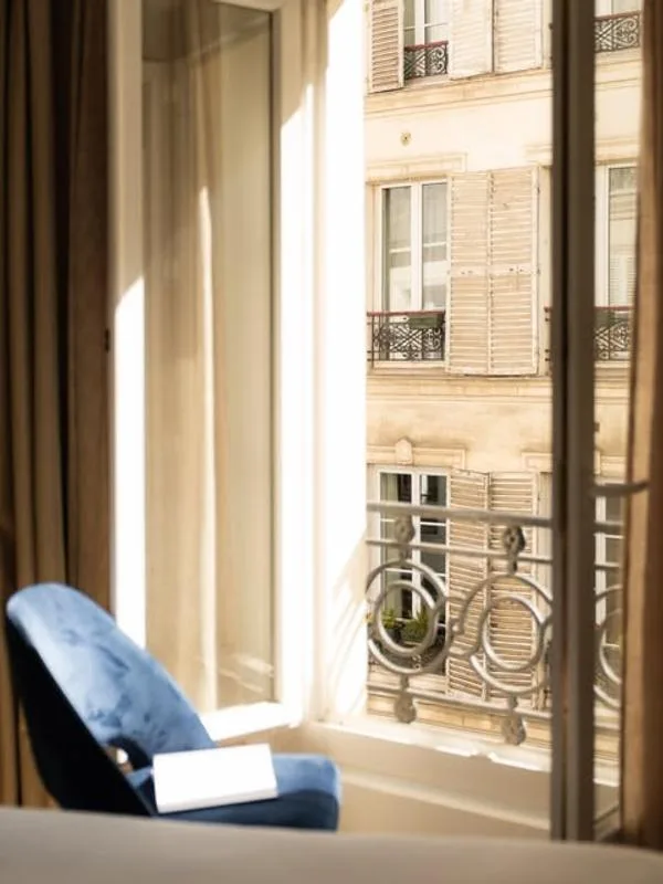 Representative hotel space: A sunlit seating area beside a tall window overlooking a neighboring building.